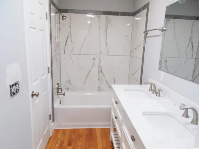 an empty room with wooden floor and a ceiling fan