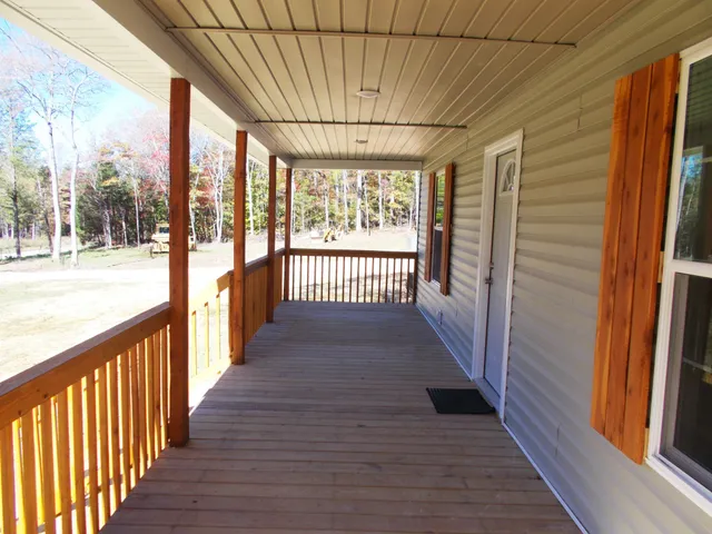 a view of a porch with wooden floor and furniture