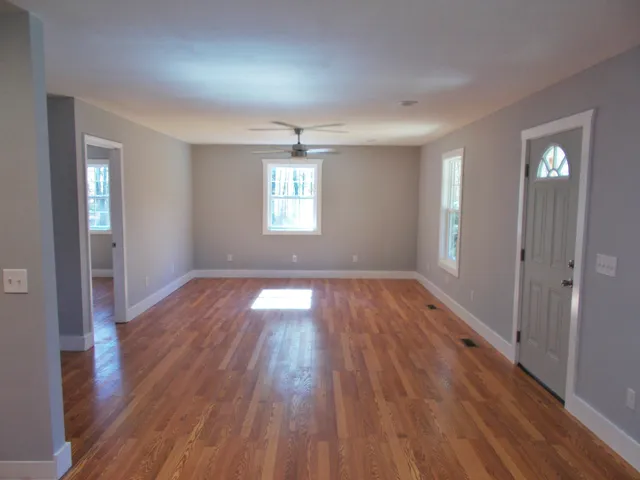 wooden floor in an empty room with a window