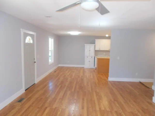 a view of empty room with wooden floor