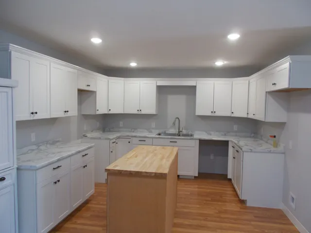 a kitchen with a sink stove top oven and cabinets