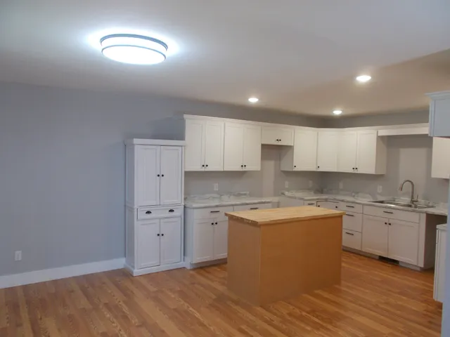 a kitchen with cabinets and wooden floor