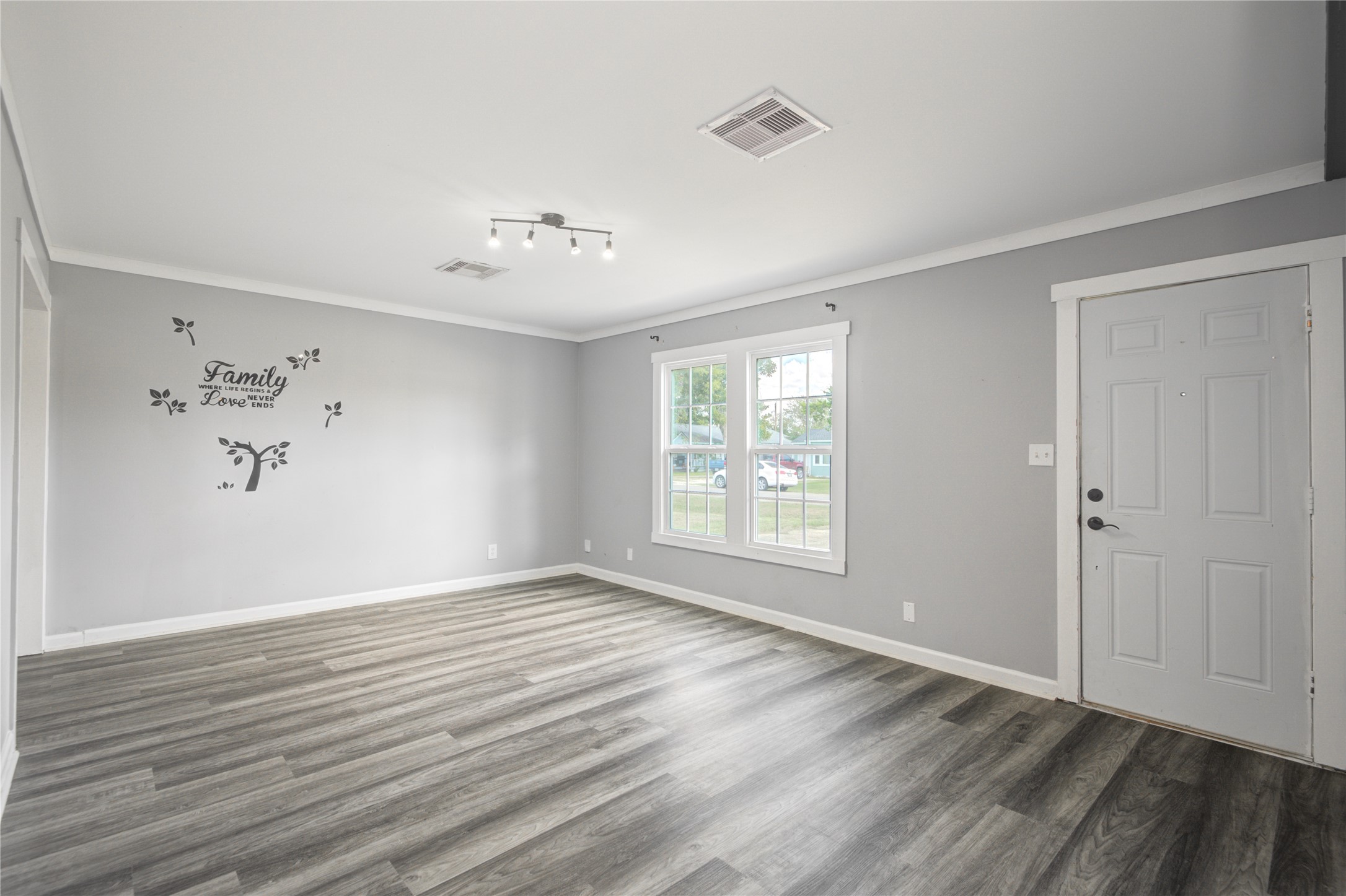 609 Hurst Place Angleton, TX 77515 - Photo 10 of 36 a view of an empty room with wooden floor and a window
