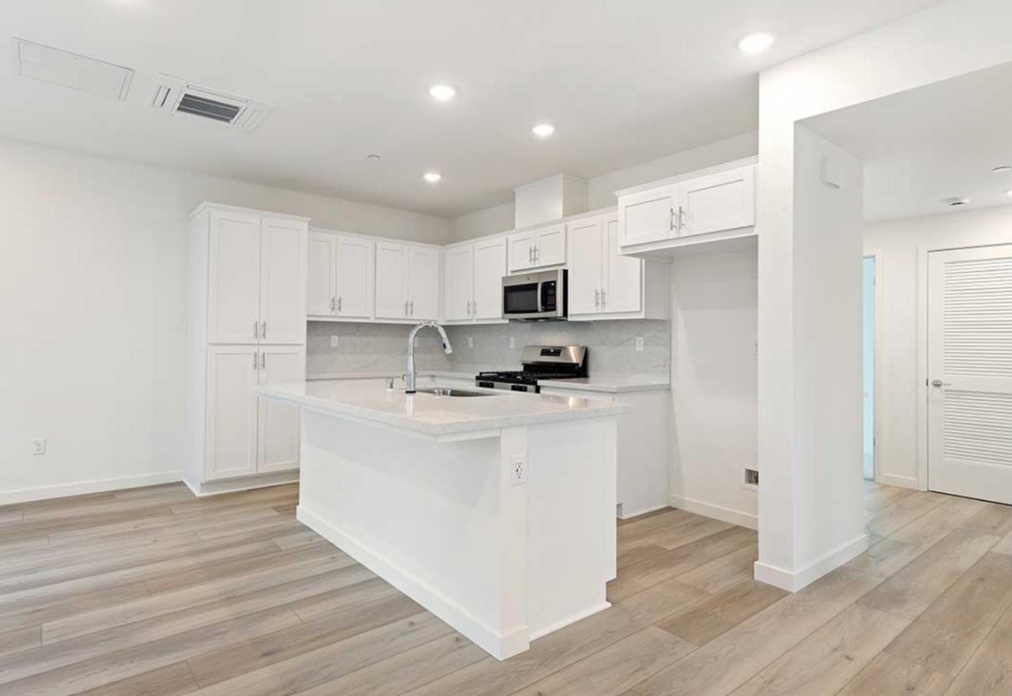 6681 Optimum Loop San Jose, CA 95119 - Photo 14 of 33 a kitchen with stainless steel appliances white cabinets a sink a stove a refrigerator and microwave