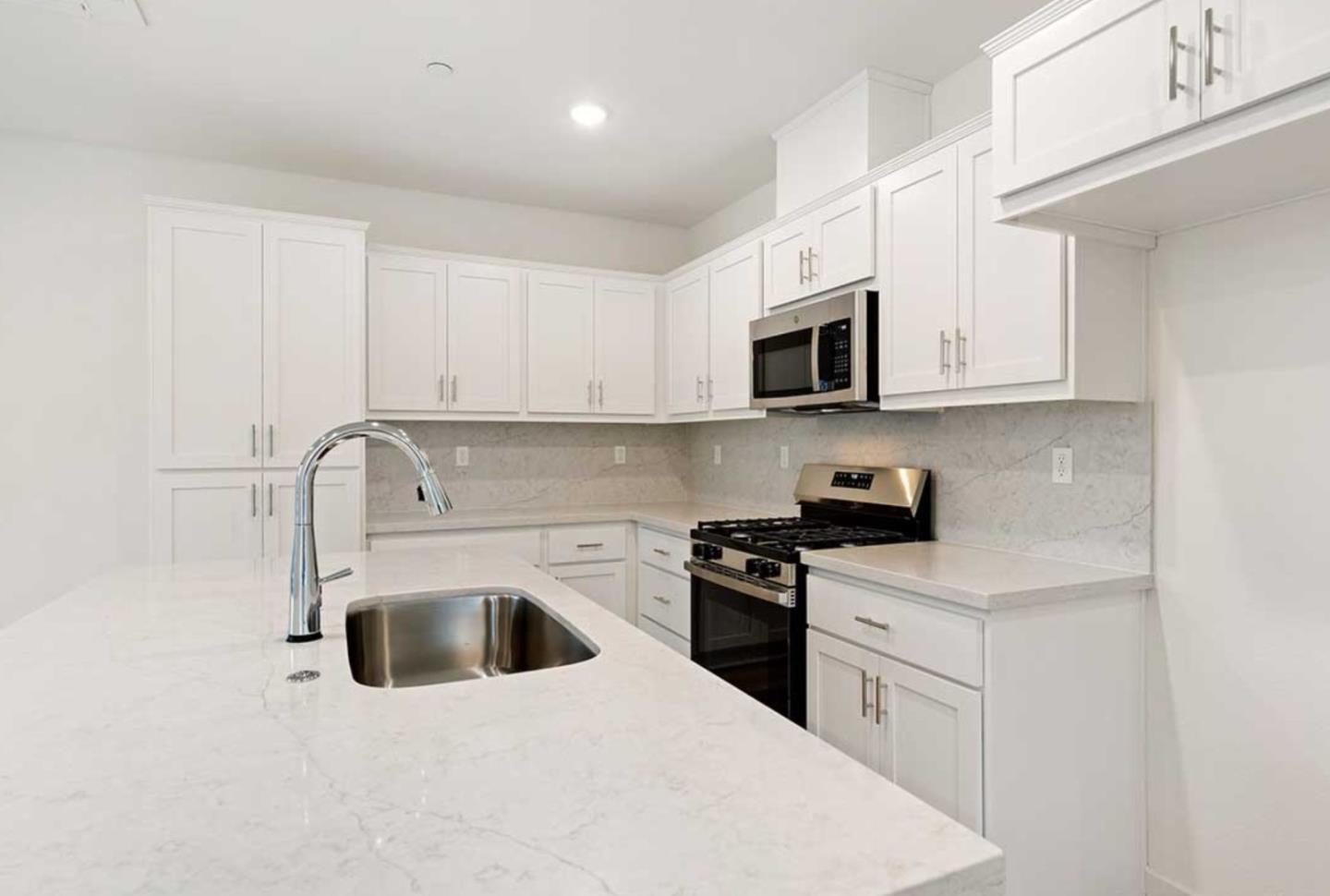 6681 Optimum Loop San Jose, CA 95119 - Photo 15 of 33 a kitchen with stainless steel appliances granite countertop white cabinets a sink a stove a microwave and a refrigerator