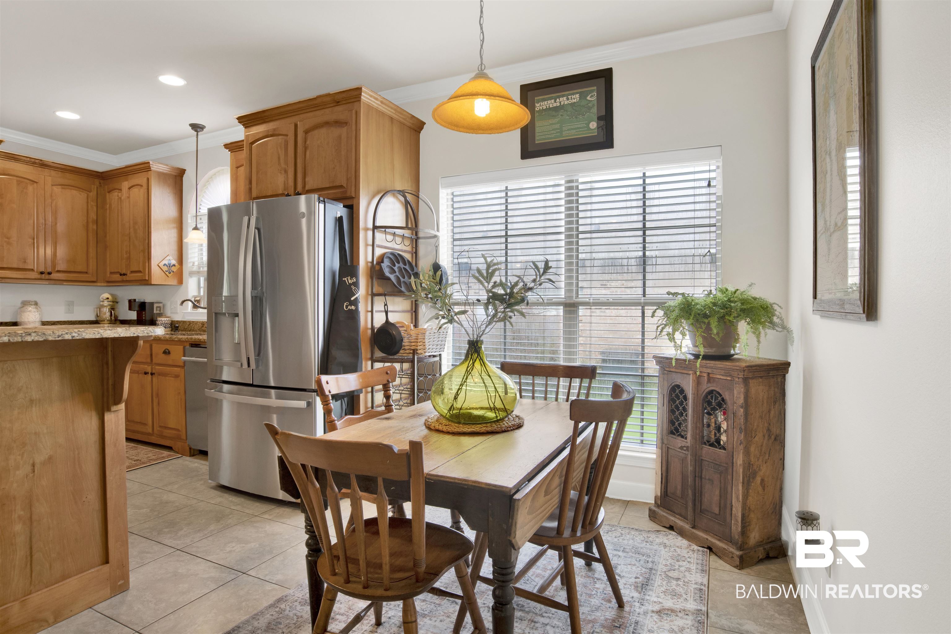 10368 Gayfer Rd Extension Fairhope, AL 36532 - Photo 16 of 43 Kitchen area featuring ample wood cabinetry, a stainless steel refrigerator, and a kitchen island with a stone-finish countertop