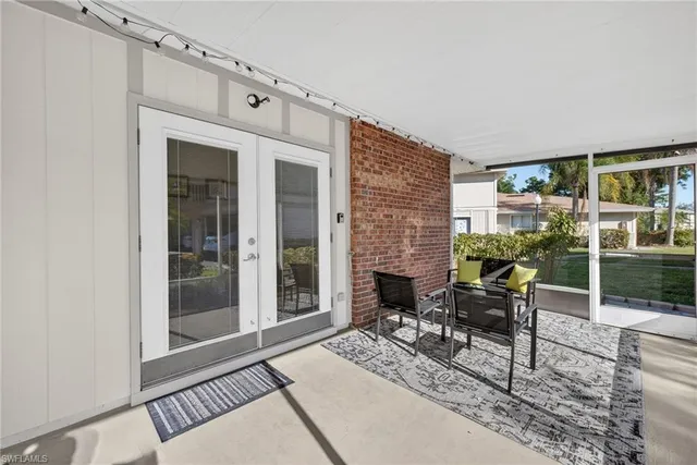 a living room with furniture a fireplace and a floor to ceiling window