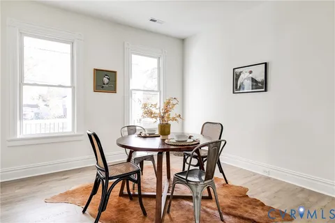 a view of a dining room with furniture and a potted plant