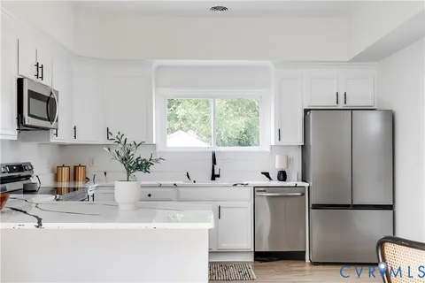 a kitchen with appliances a sink and a refrigerator