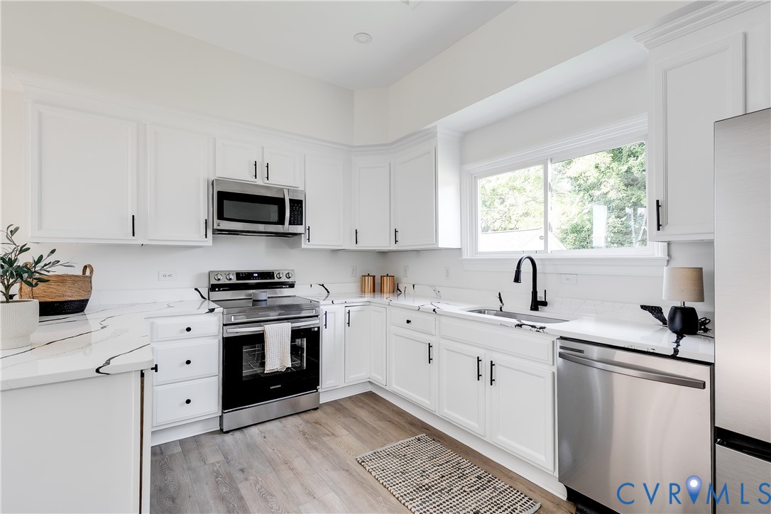 2413 Ingram Avenue Richmond, VA 23224 - Photo 18 of 43 a kitchen with cabinets appliances a sink and a window