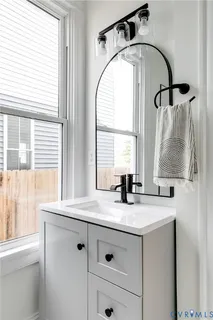 a bathroom with a granite countertop sink a window and a mirror