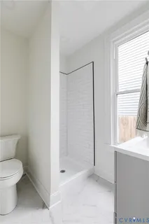 a bathroom with a toilet and a shower