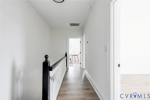 a view of a hallway with wooden floor