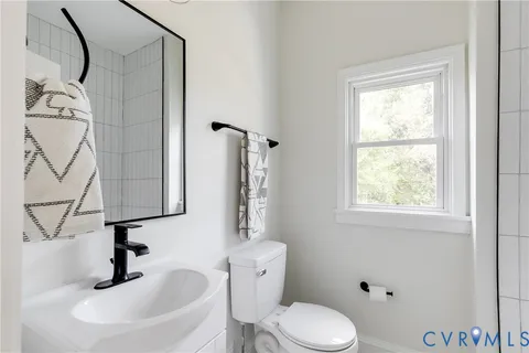 a bathroom with a sink a toilet and a window