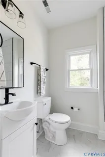 a white toilet sitting next to a bathroom sink