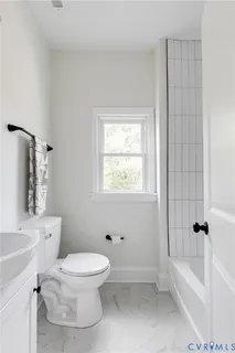 a white toilet sitting next to a bath tub