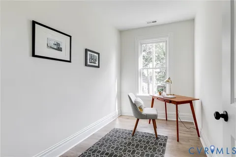 a view of a workspace with furniture and a window