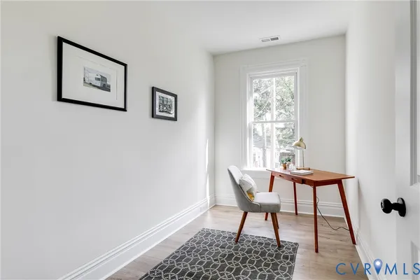 a view of a workspace with furniture and a window