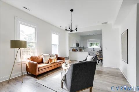 a living room with furniture and a chandelier