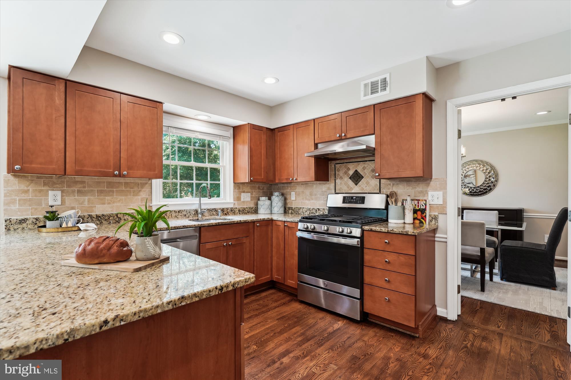 5427 Rilian Court Burke, VA 22015 - Photo 11 of 63 a kitchen with stainless steel appliances granite countertop wooden cabinets a stove top oven a sink and dishwasher with wooden floor