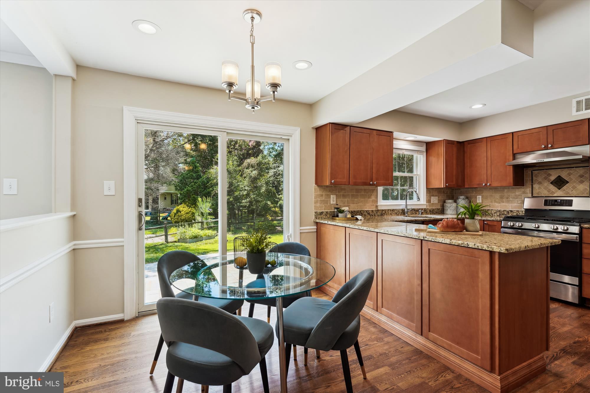 5427 Rilian Court Burke, VA 22015 - Photo 13 of 63 a kitchen with stainless steel appliances granite countertop a stove top oven a sink dishwasher a dining table and chairs with wooden floor