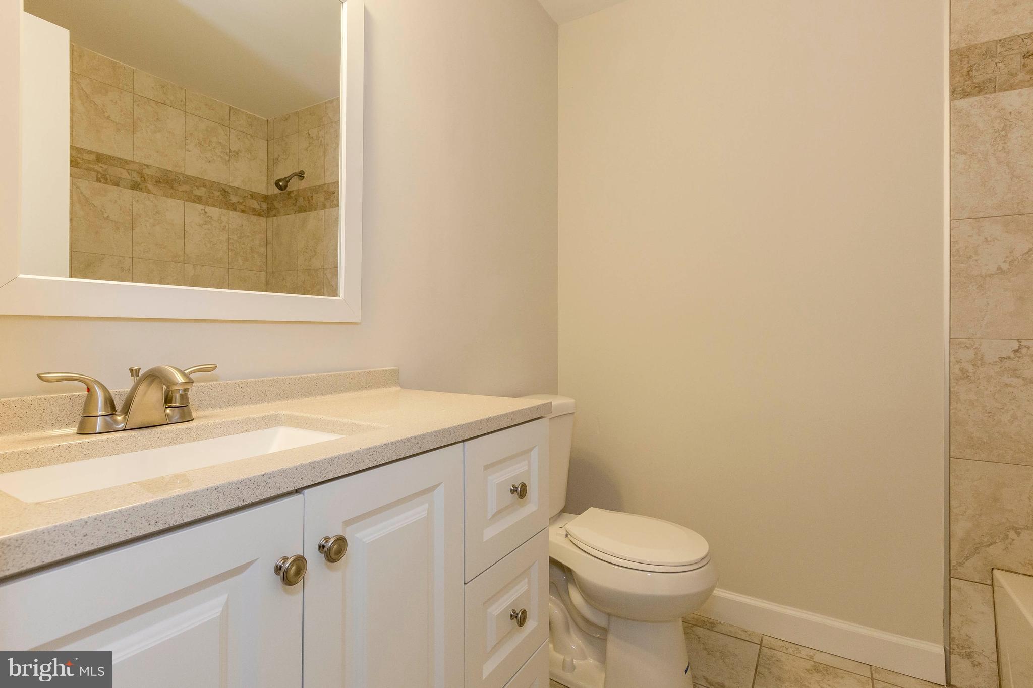 6158 Stevens Forest Road Columbia, MD 21045 - Photo 14 of 30 a bathroom with a granite countertop sink toilet and a mirror