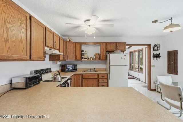 a kitchen with stainless steel appliances granite countertop a refrigerator stove top oven a sink and dishwasher