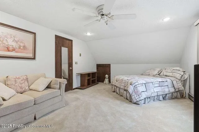 a spacious bedroom with a bed and ceiling fan