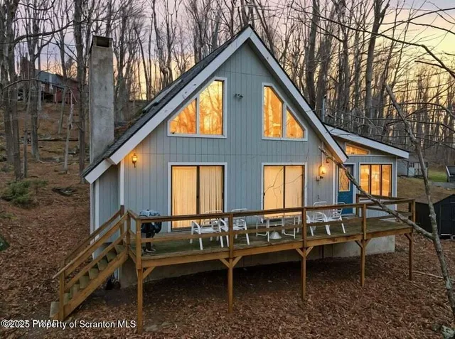 a view of a house with pool and chairs