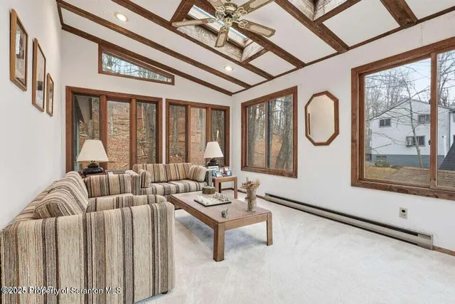 a living room with furniture a large window and a chandelier