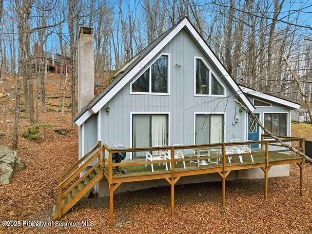 a view of a house with a yard and large trees