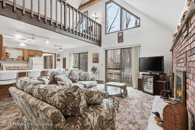 a living room with furniture a flat screen tv and kitchen view