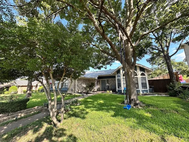 a front view of a house with yard and green space