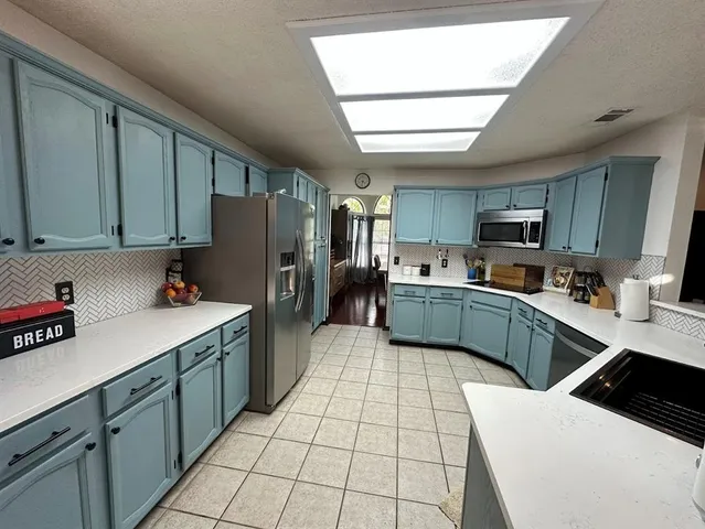 a kitchen with stainless steel appliances a refrigerator sink stove microwave and cabinets