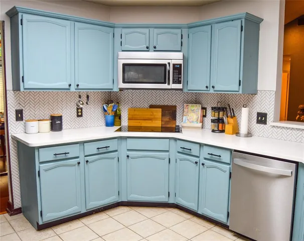 a kitchen with cabinets stainless steel appliances and a sink