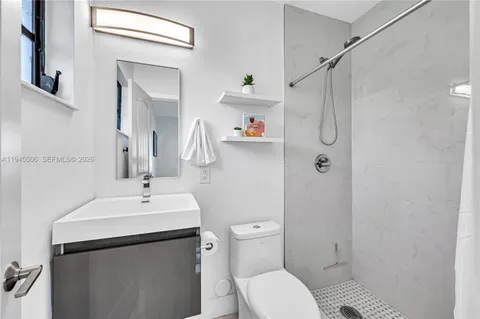 a bathroom with a sink toilet and shower