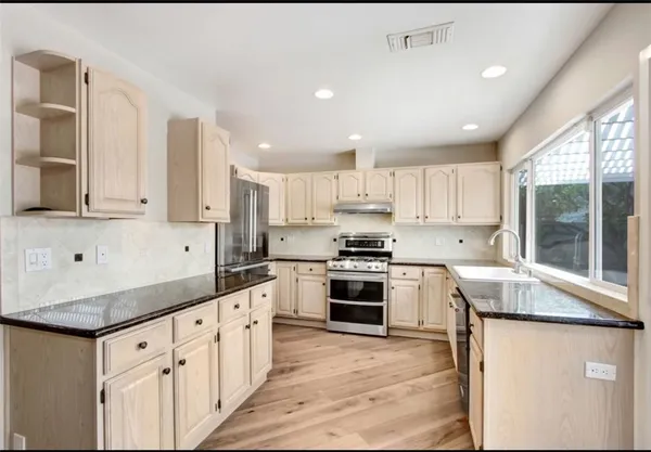 a kitchen with granite countertop white cabinets and white appliances