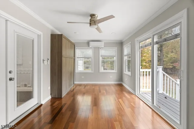 a view of a livingroom with wooden floor and a ceiling fan