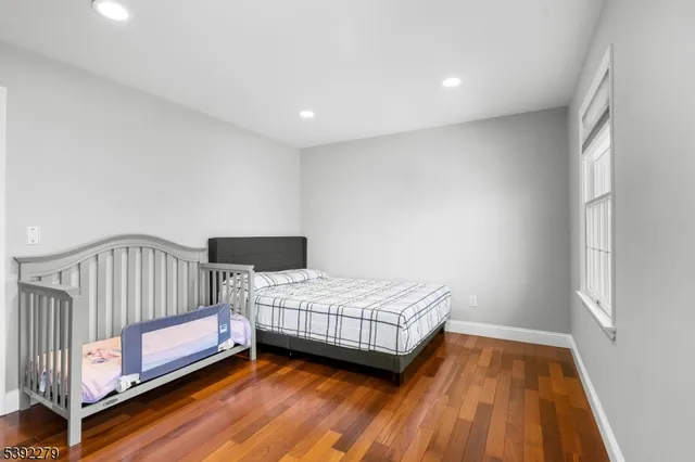 a spacious bedroom with a bed and a wooden floor