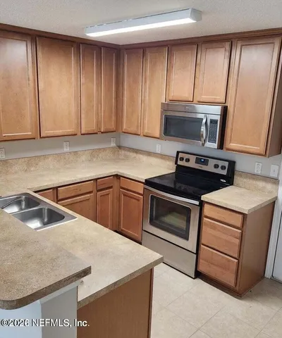 a kitchen with a sink stove and cabinets