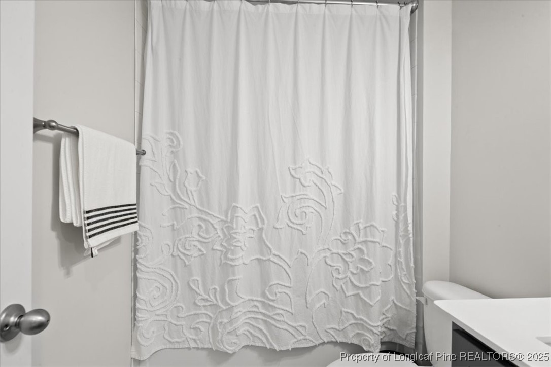 7840 Rufus Johnson Road Fayetteville, NC 28306 - Photo 13 of 50 a bathroom with a shower curtain