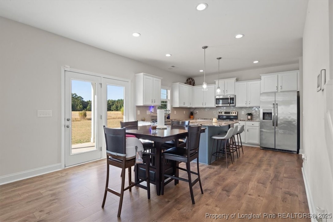 7840 Rufus Johnson Road Fayetteville, NC 28306 - Photo 19 of 50 a view of a dining area kitchen with furniture and wooden floor