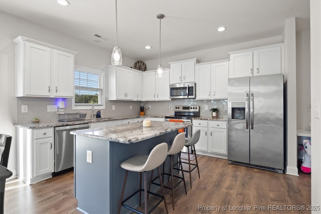 7840 Rufus Johnson Road Fayetteville, NC 28306 - Photo 22 of 50 a kitchen with stainless steel appliances granite countertop a table chairs sink refrigerator and microwave