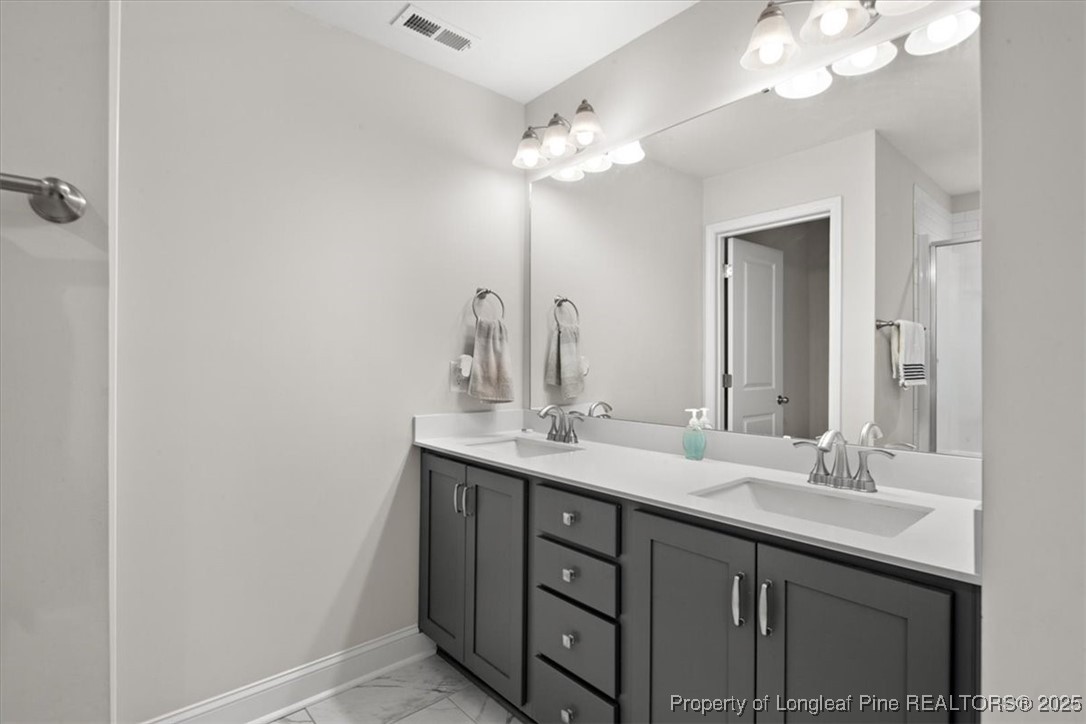 7840 Rufus Johnson Road Fayetteville, NC 28306 - Photo 46 of 50 a bathroom with a double vanity sink and a mirror