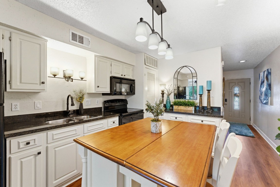 12900 Walden Road, Unit 219B Montgomery, TX 77356 - Photo 13 of 41 a kitchen with stainless steel appliances granite countertop a sink and cabinets with wooden floor