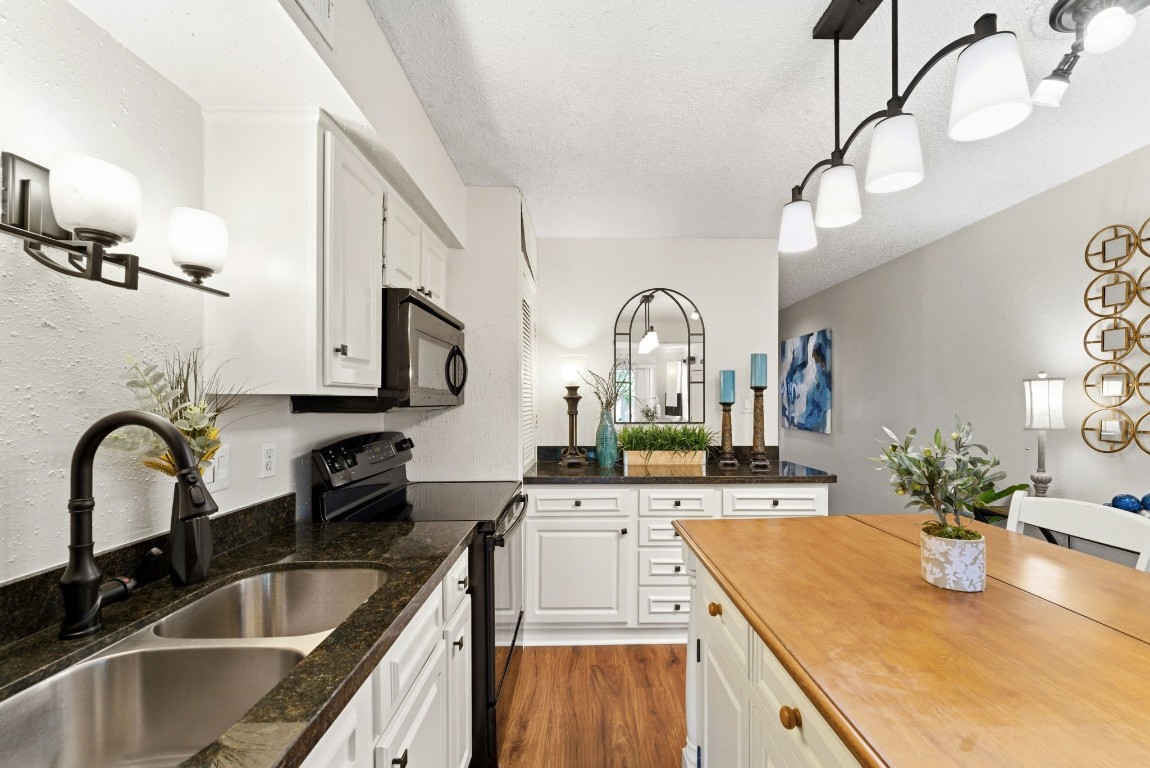 12900 Walden Road, Unit 219B Montgomery, TX 77356 - Photo 14 of 41 a kitchen with kitchen island granite countertop a sink a counter space and cabinets