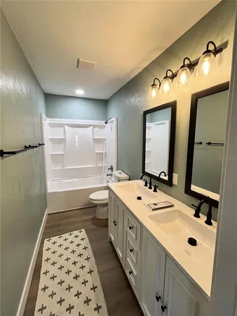 a bathroom with a double vanity sink double vanity mirror and a bathtub