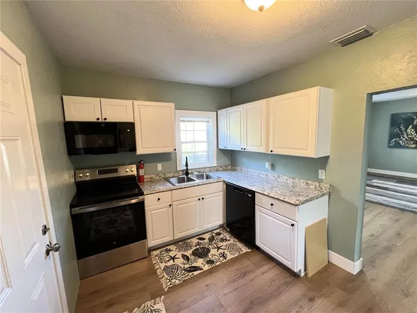 a kitchen with a sink stove and microwave