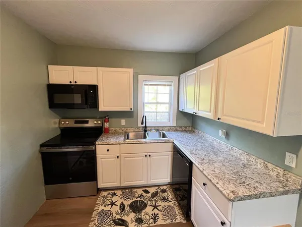 a kitchen with a sink stove and microwave