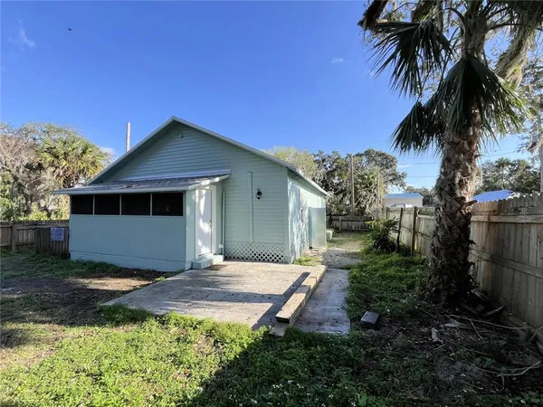 a front view of house with yard and trees in the background